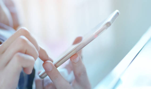 スマホを持つ女性の写真