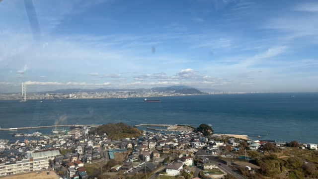 観覧車のゴンドラから見下ろした、淡路島の街並みと青い海の景色。